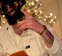 Alternative pop artist Nevv Evve holding a drink and notebook while developing new music ideas, representing the artist journey, behind-the-scenes content, and exclusive updates available through the Nevv Evve email list.