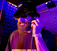 Nevv Evve alternative pop artist wearing luxury accessories while in a recording studio inviting fans to join the music subscriber list for new releases, exclusive updates, and behind-the-scenes content.